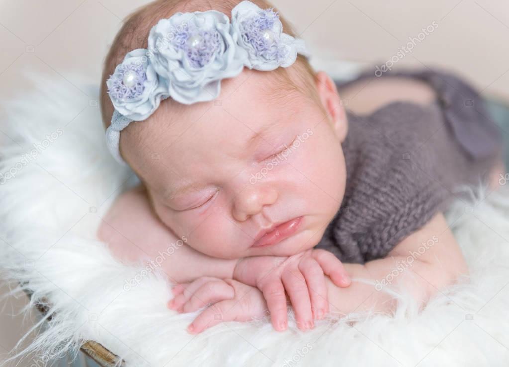 infant girl with flowery hairband sleeping