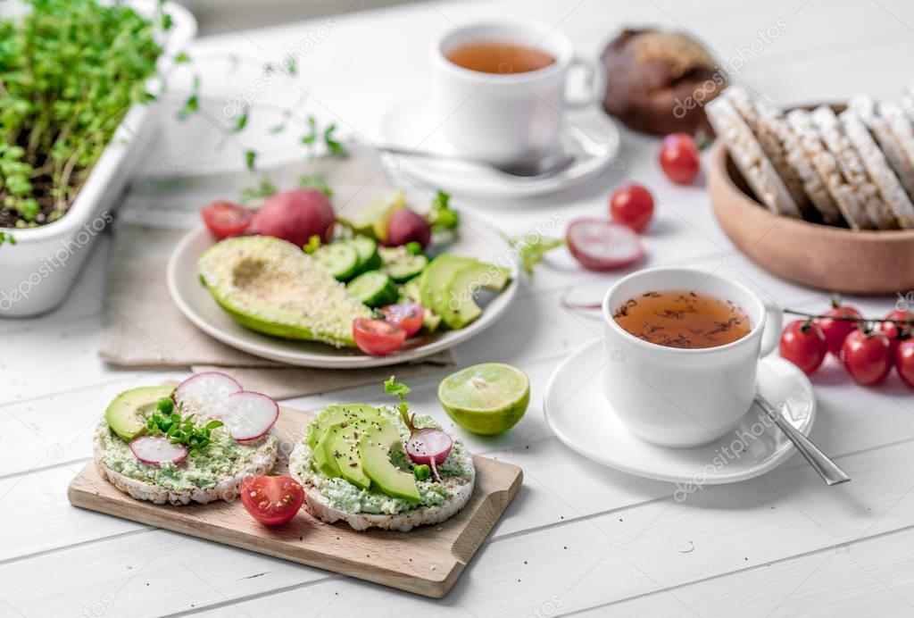 Flatbread with avocado and raddish, cup of tea