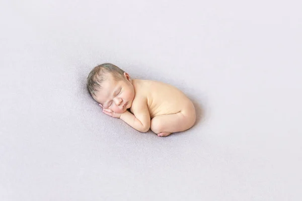 Naked baby sleeping on belly, curled up — Stock Photo, Image