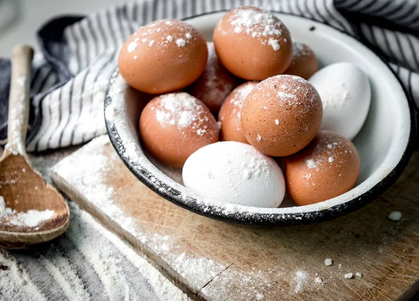 Eggs in tin bowl, brown spoon, blue napkin — Stock Photo, Image