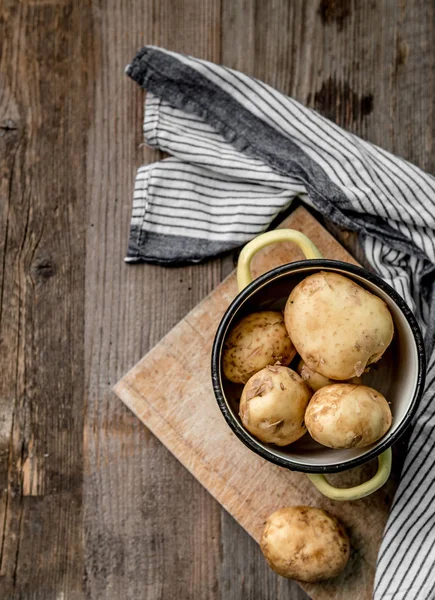 Young potatoes sitting on cutting board, topview — Stock Photo, Image