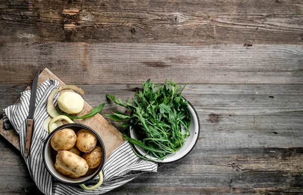 Young potatoes and fresh arugula, topview, textspace left — Stock Photo, Image