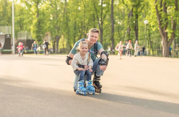 Маленька дівчинка і її батько позує і катається на роликах — стокове фото