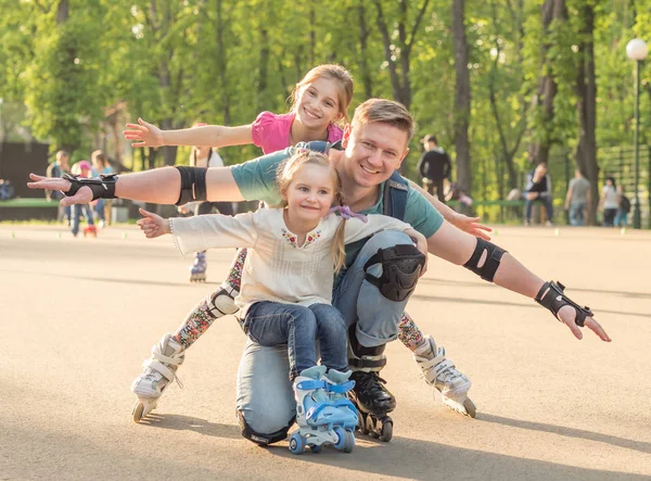 Systrar och deras far poserar rullskridskoåkning — Stockfoto