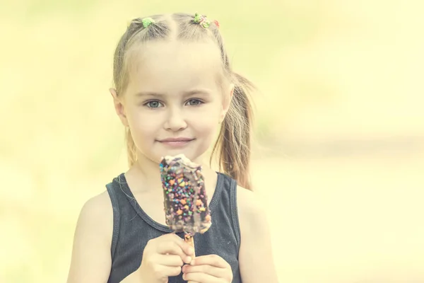 Bambino in campo mangiare gelato — Foto Stock