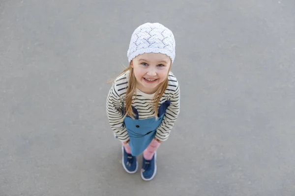 Menina de chapéu branco em pé fora, sorrindo — Fotografia de Stock