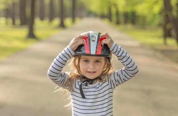 Kleines Mädchen im Helm für die Rolle draußen — Stockfoto