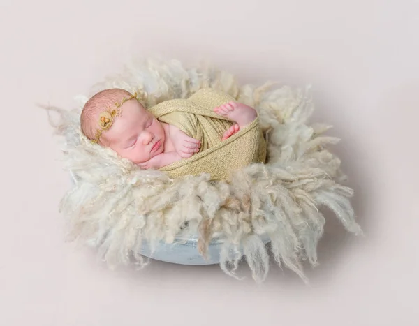 Swaddled kid tupplur på gulaktig lurviga kudde — Stockfoto