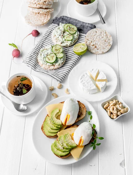 Здоровый завтрак с тостами из цельного хлеба, авокадо, яйцами — стоковое фото