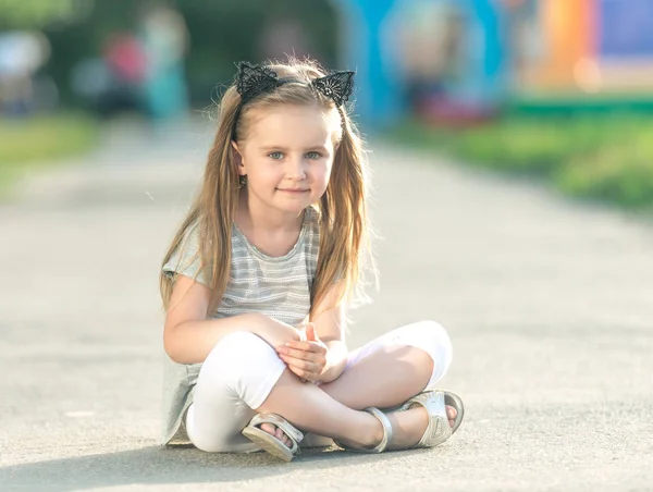 Niña feliz está sentada —  Fotos de Stock