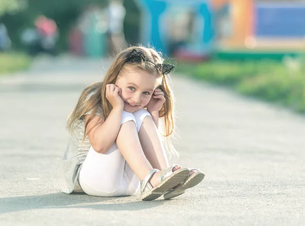 Pequena menina feliz está sentado — Fotografia de Stock