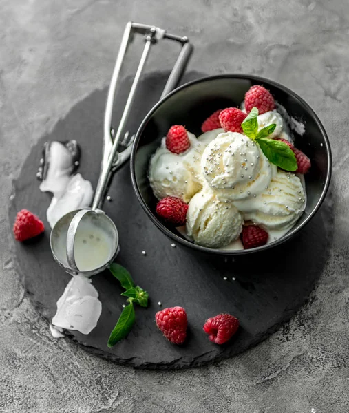 Helado con frambuesas servido en piala negra —  Fotos de Stock