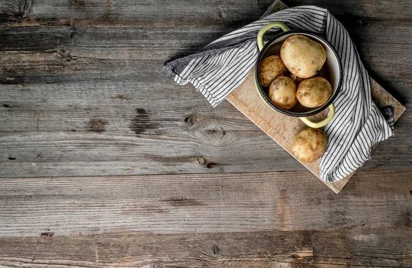 Jeunes pommes de terre assises sur la planche à découper, vue de dessus — Photo