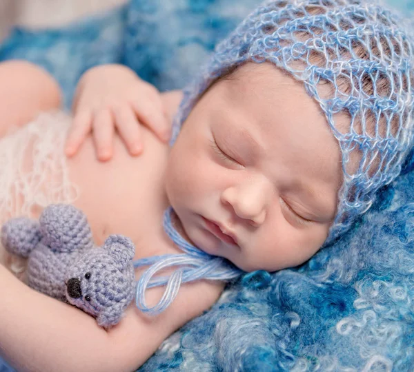 可爱的新生儿在蓝色的帽子配小玩具 — 图库照片