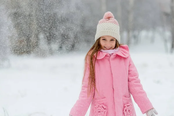 Menina sorridente em turbilhão de flocos de neve — Fotografia de Stock