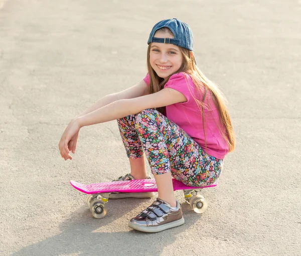 Ragazza con i capelli lunghi seduta su skating board — Foto Stock