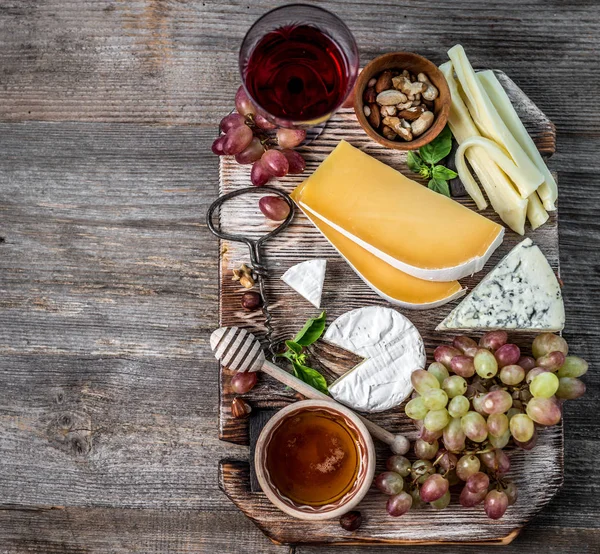 Kaasschotel geserveerd met wijn, noten en honing — Stockfoto