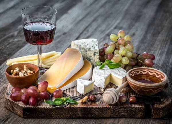 Plato de queso servido con vino, nueces y miel — Foto de Stock