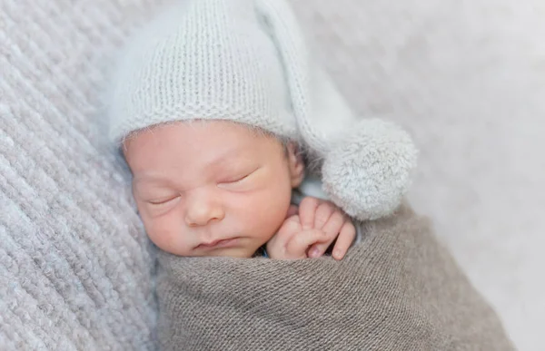 Slapen van de pasgeboren jongen in een hoed — Stockfoto