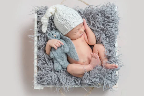 Menino recém-nascido adormecido com uma lebre — Fotografia de Stock