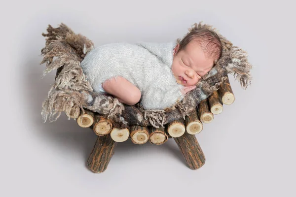 Menino recém-nascido adormecido em uma cama de madeira — Fotografia de Stock