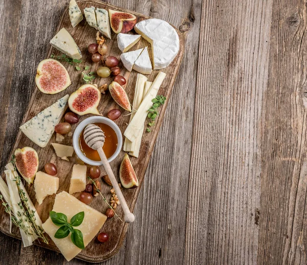 Сырная тарелка с вином, орехами и медом — стоковое фото