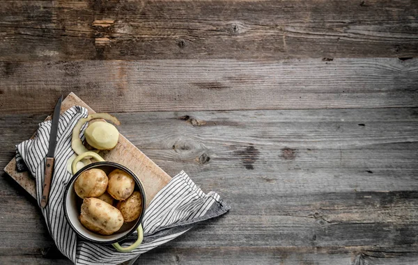 Patate giovani sedute sul tagliere, vista dall'alto — Foto Stock