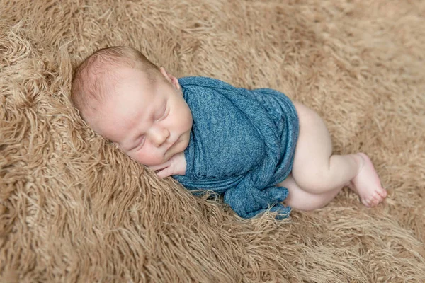 Klein kind verpakt in een blauwe sjaal — Stockfoto