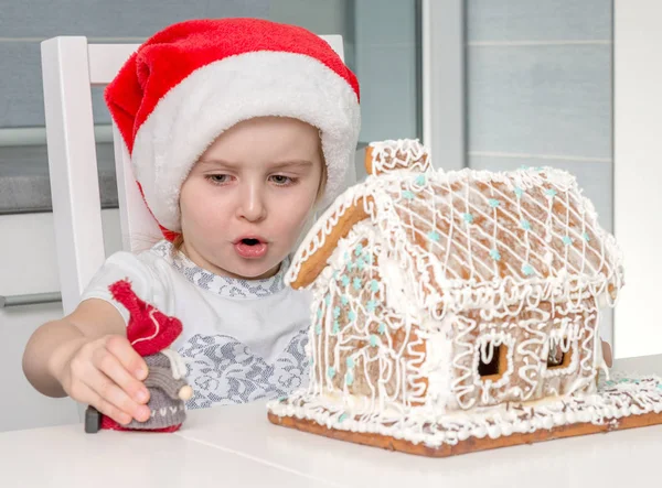 Bonito menina brinquedo perto de biscoito casa — Fotografia de Stock