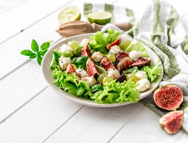 Ensalada con higos, mozzarella y uvas sobre fondo de madera blanca . —  Fotos de Stock