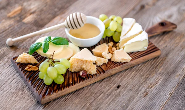 Prato de queijo servido com nozes e mel — Fotografia de Stock