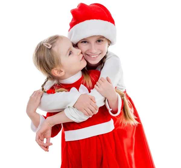 Two happy little girls in santa suits embracing — Stock Photo, Image