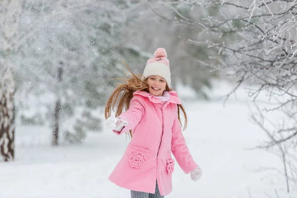 Liten flicka kastar snö upp i luften — Stockfoto