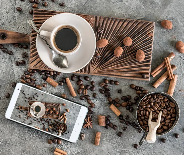 Svart kaffe med godis på en konkret bakgrund ovanifrån — Stockfoto