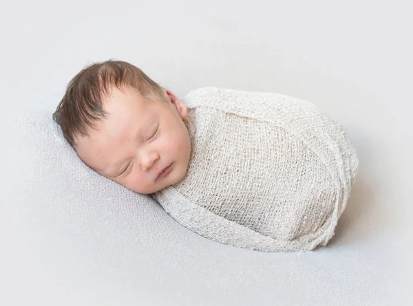 Adorável bebê dormindo envolto em um envoltório, close-up — Fotografia de Stock