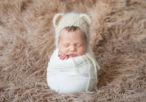 Niño envuelto con manta blanca, durmiendo en la superficie peluda — Foto de Stock