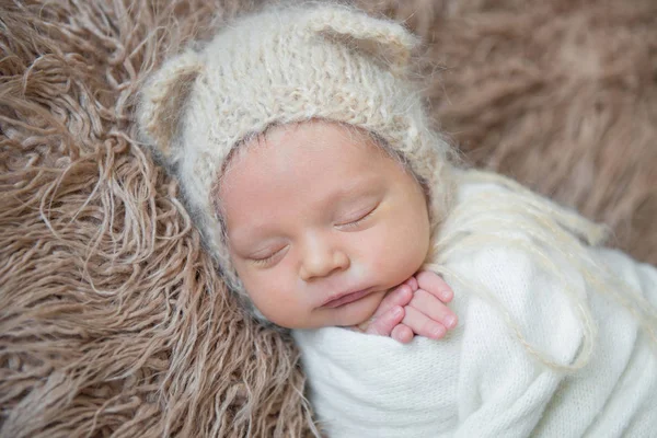 Bambino avvolto con coperta bianca, che dorme su una superficie pelosa — Foto Stock