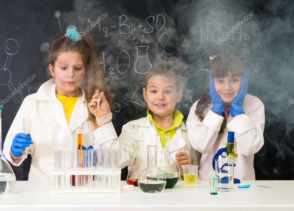 three excited children after chemical experiment