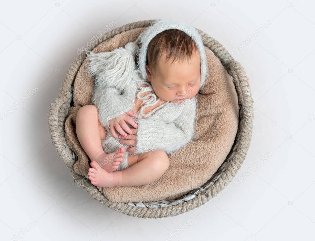 Top view of newborn baby boy laying in a bowl