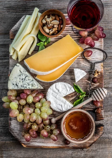 Plato de queso servido con vino, nueces y miel — Foto de Stock