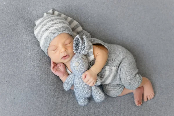 Menino recém-nascido adormecido com uma lebre — Fotografia de Stock