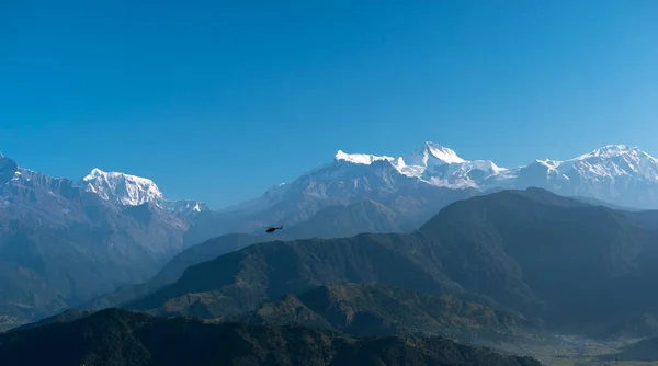 Hubschrauber fliegen zwischen Bergen, Pokhara, Nepal. — Stockfoto
