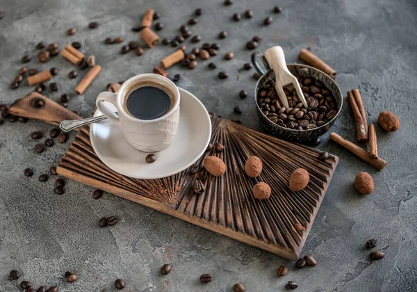 Zwarte koffie met snoepjes op een concrete achtergrond — Stockfoto