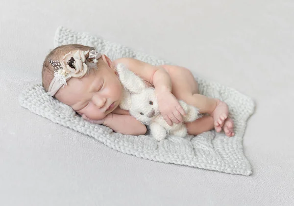 Schlafendes Baby mit Spielzeug auf einer Strickdecke — Stockfoto