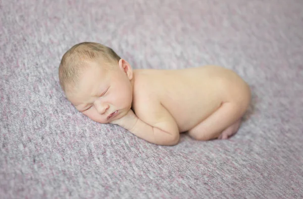 Pasgeboren meisje slapen op haar zijde in de hairband van de bloem, close-up — Stockfoto