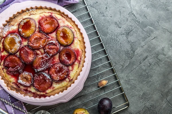 Torta de ameixa caseira em um fundo de concreto vista superior — Fotografia de Stock