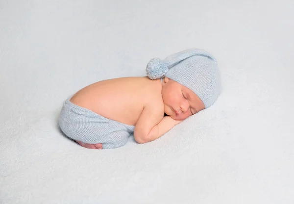 Babyjongen opgerold op witte deken — Stockfoto