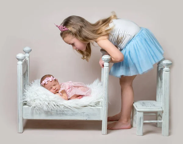 Menina senta-se ao lado de sua irmã recém-nascida — Fotografia de Stock