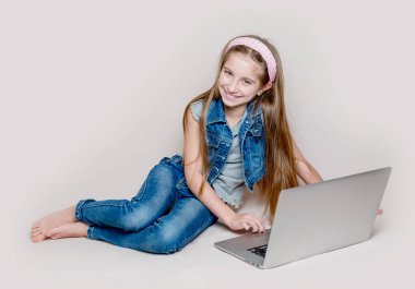 Laptop ile yerde yatarken Litlle kız