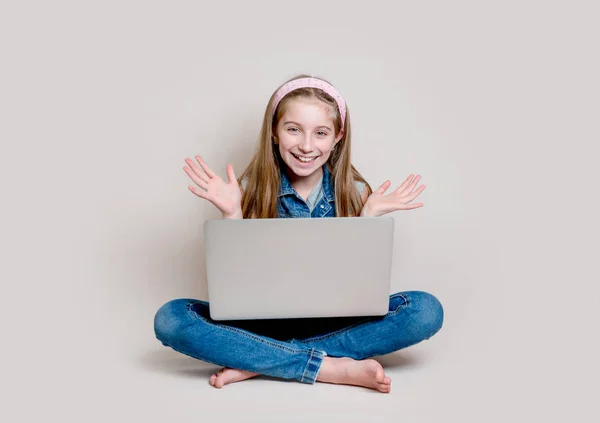 Glad liten flicka sitter på golvet med laptop — Stockfoto